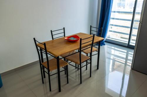 a wooden table with four chairs and a plate on it at Apartamento Novo, Brand New Apartament T1, Cidadela, Praia, Cabo Verde in Praia