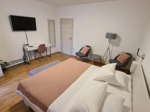 a bedroom with a bed and a desk and chairs at Apartments & Rooms Tom in Medulin