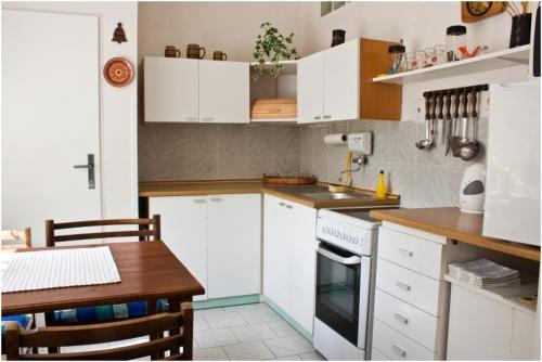 une cuisine avec des placards blancs et une table en bois dans l'établissement Privat No. 40, à Telč