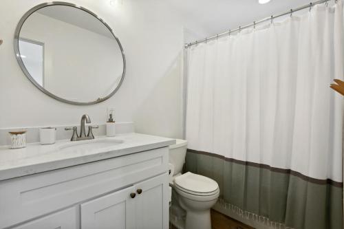 a white bathroom with a sink and a mirror at Vacation Rental Old Town Bay St Louis Unit B in Bay Saint Louis