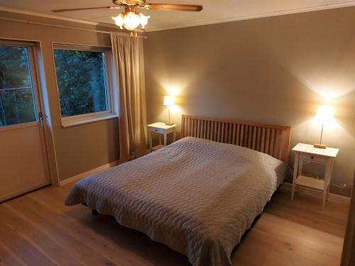 um quarto com uma cama e duas mesas com candeeiros em Vitahuset, 1 min Vallentuna Idrottsplats em Vallentuna
