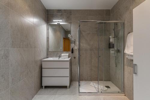 a bathroom with a shower and a sink and a mirror at BNBHolder Apartamentos en Sol Confort 8 in Madrid