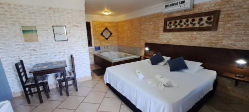 a bedroom with a bed and a tub in a room at Pousada Cheiro de Mato in Penedo