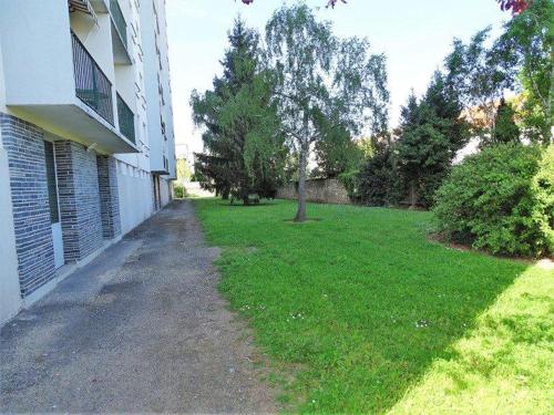 un patio de césped junto a un edificio con un árbol en Tours centre, en Tours