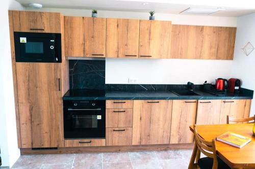 a kitchen with wooden cabinets and a black appliance at Chez Marien in Malaucène