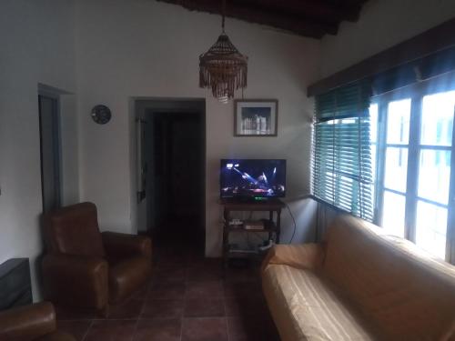 sala de estar con sofá y TV en Casita de mis viejos en Mendoza