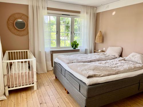 - une chambre avec un lit, une fenêtre et un lit bébé dans l'établissement Villa Rye Street Kolmården, à Kolmården