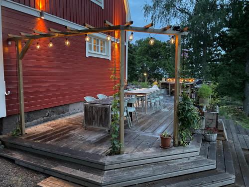 une terrasse en bois avec une table et des chaises sur une maison dans l'établissement Villa Rye Street Kolmården, à Kolmården