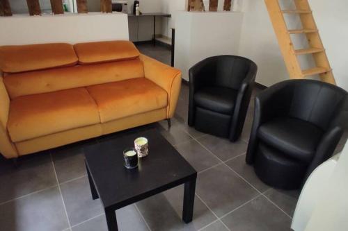 - un salon avec un canapé et deux chaises dans l'établissement Appartement hyper centre Mayenne, à Mayenne