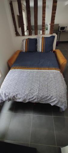 - un grand lit avec une couette bleue et blanche dans l'établissement Appartement hyper centre Mayenne, à Mayenne