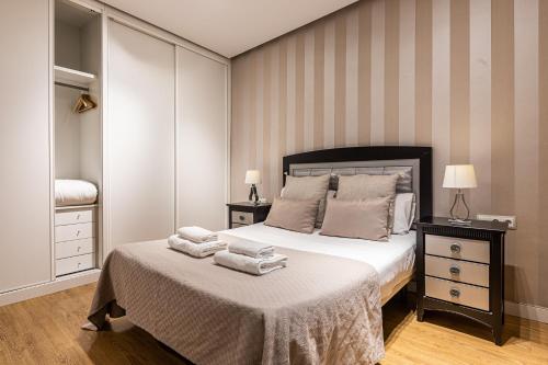 um quarto com uma cama com toalhas em BNBHolder Apartamentos en Sol Deluxe 2 em Madrid