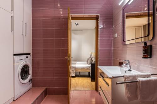 uma casa de banho com um lavatório e uma máquina de lavar roupa em BNBHolder Apartamentos en Sol Deluxe 2 em Madrid