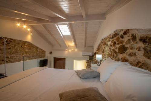 a bedroom with a large bed with a stone wall at stone house in Mantoúkion