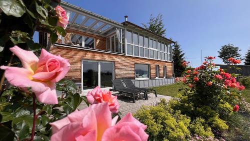 a house with a bench and flowers in front of it at CR25 - more than a room in Immenstadt im Allgäu