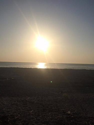 a sunset on the beach with the ocean in the background at B&B Indipendenza in Civitanova Marche