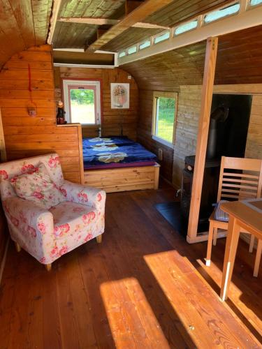 a room with a bed and a chair in a cabin at Zirkuswagen im Weserbergland in Aerzen