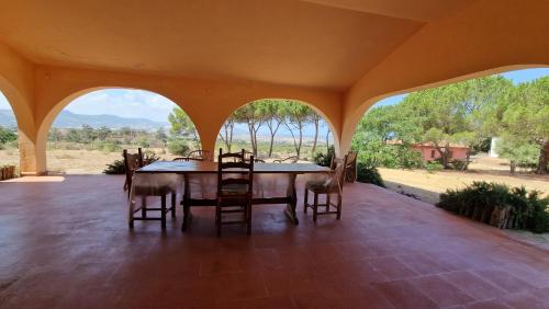 Un comedor con mesa y sillas en un patio. en Villa Jolies, en Viddalba