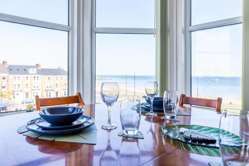a dining room table with glasses and plates on it at The Priory House in Tynemouth