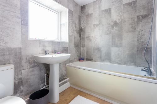 a bathroom with a sink and a tub and a toilet at The Priory House in Tynemouth