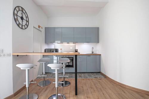 een keuken met een aanrecht en krukken in een kamer bij L'Oasis de la Comédie, 4 Personnes, Parking Privé, Climatisation & Wifi in Montpellier