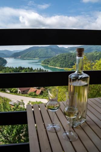 a bottle of wine and two glasses on a table at Villa Montana Zaovine in Bajina Bašta