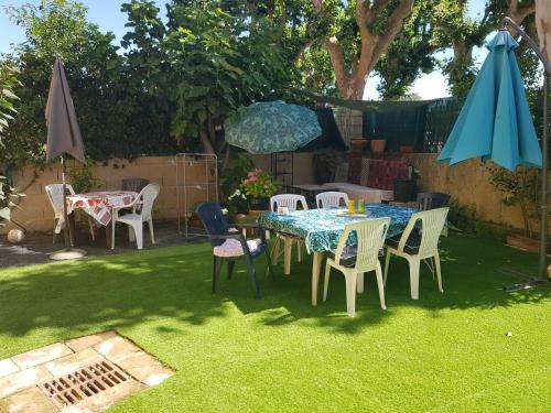 a table and chairs and an umbrella in a yard at Maison au Pied du Pont du Gard in Remoulins