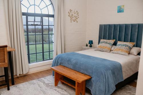 a bedroom with a bed and a large window at Mooi Uitsig Lodge in Paarl