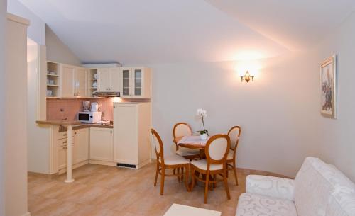 a living room with a table and chairs and a kitchen at Hotel Sunceva Postelja Brela in Brela
