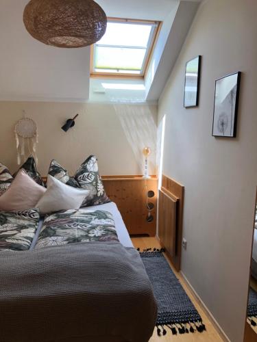 a bedroom with a bed with pillows and a window at Ferienhaus Mautzfried in Reisach