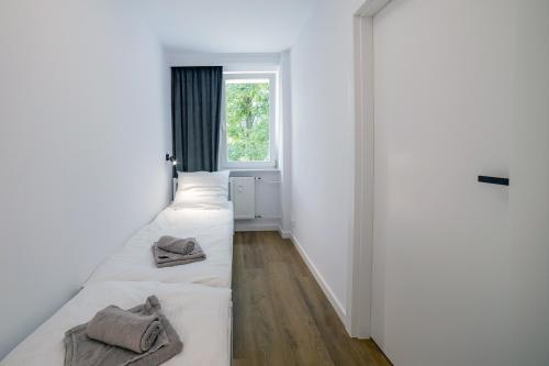 two beds in a room with a window at Apartament Alpaka 1 in Lidzbark Warmiński