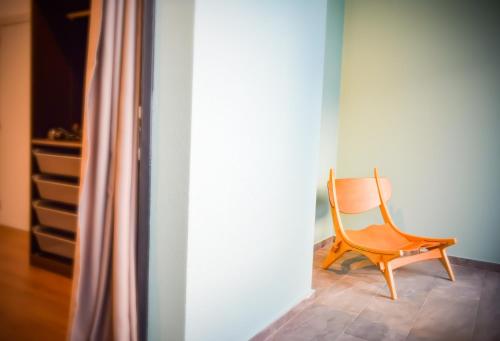 a wooden chair sitting in a corner of a room at CBA Suites Madeira in Funchal
