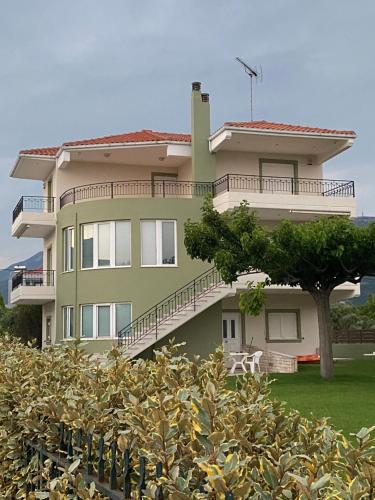 una casa grande con un árbol delante en Country house Nafpaktos en Nafpaktos