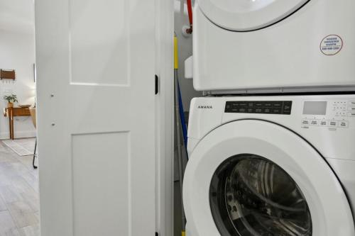 a washing machine is next to a white door at Cozy Vacation Rental in Old Town Bay St Louis Unit C in Bay Saint Louis