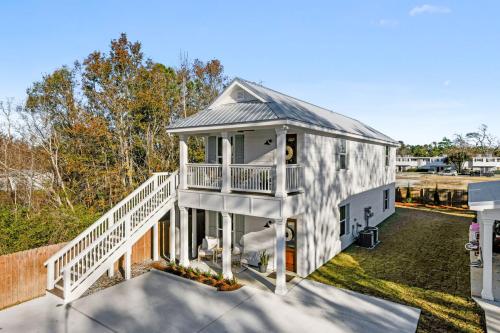 a large white house with a porch and a deck at Cozy Vacation Rental in Old Town Bay St Louis Unit C in Bay Saint Louis