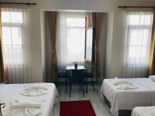 Habitación con 2 camas, mesa y espejo. en Halil Bey Konağı en Estambul