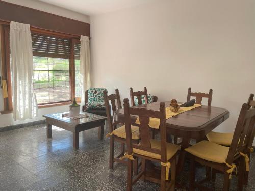 sala de estar con mesa de comedor y sillas en La Casita de Córdoba en Capilla del Monte