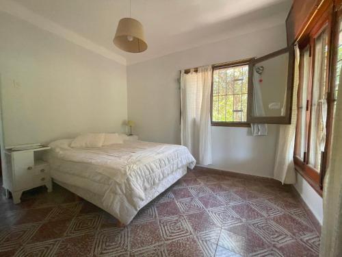 1 dormitorio con cama y ventana en La Casita de Córdoba en Capilla del Monte
