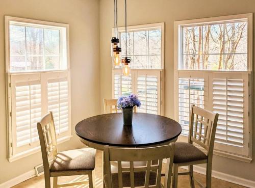 a dining room with a table and chairs and windows at Oasis on 151 - Ideal Location on Brew Ridge Trail in Faber