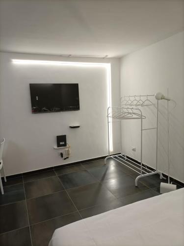 Habitación blanca con TV de pantalla plana en la pared en Casa degli Scalzi 43, en Nápoles