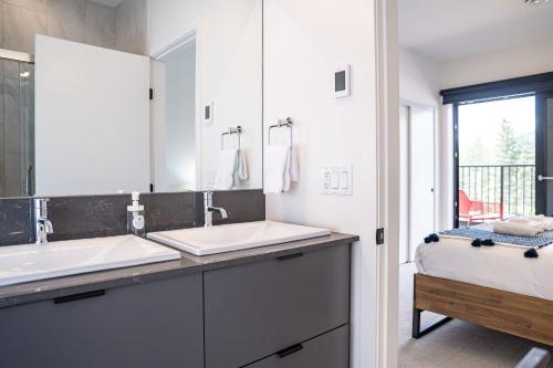 a bathroom with two sinks and a large mirror at Stoke House by Revelstoke Vacations in Revelstoke
