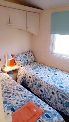 a small bedroom with two beds and a window at Brittany's in Gisburn