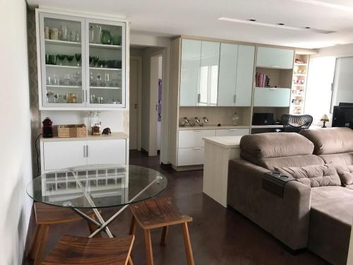 uma sala de estar com um sofá e uma mesa de vidro em Condominio Felice Club em Curitiba