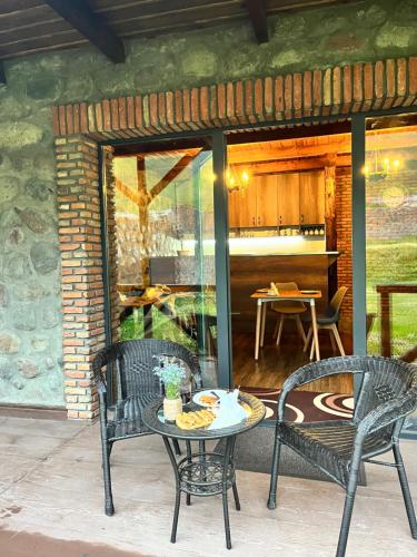 un patio con 2 sillas, una mesa y una mesa con sillas en Inn Harmony, en Kazbegi