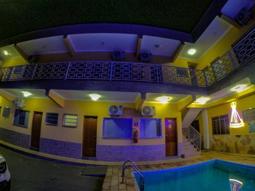 an indoor swimming pool in a building with a house at Hotel Pousada Recanto da Madá in Aparecida