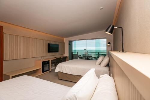 pokój hotelowy z dwoma łóżkami i telewizorem w obiekcie Ocean Palace All Inclusive Premium w mieście Natal