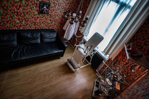 a living room with a black leather couch and a window at Vintage BDSM Kinky Apartment - ENTIRE 65m2 space for up to 6-guests - FULLY EQUIPPED in Wrocław