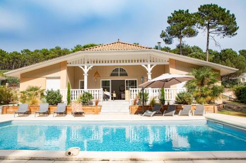 une maison avec une piscine devant dans l'établissement Belle villa familiale rénovée dans cadre exceptionnel-AG15, à Lacanau