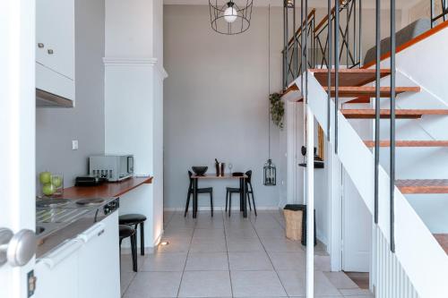 biała kuchnia ze stołem i schodami w obiekcie A & D Houses No2 w mieście Patras