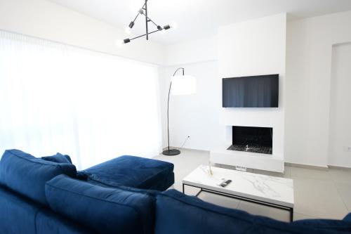 sala de estar con sofá azul y chimenea en Ennea Suites-Frost suite, en Flámbouras