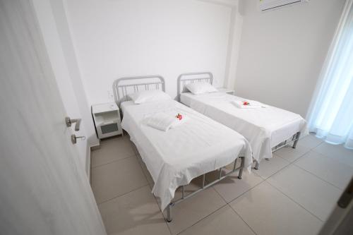 2 camas en una habitación de hospital con paredes blancas en Ennea Suites-Frost suite, en Flámbouras